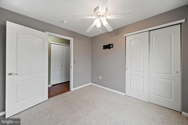 an empty room with fan and entrance