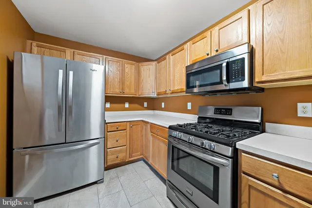 a kitchen with stainless steel appliances granite countertop a refrigerator stove top oven and sink