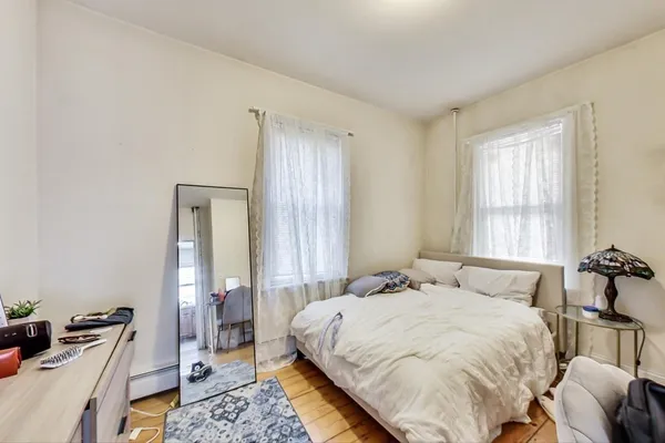 a bedroom with a bed and wooden floor