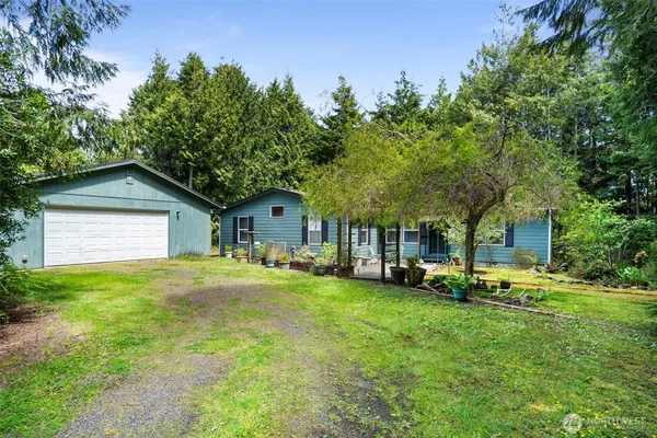 a yellow house with a big yard and large trees