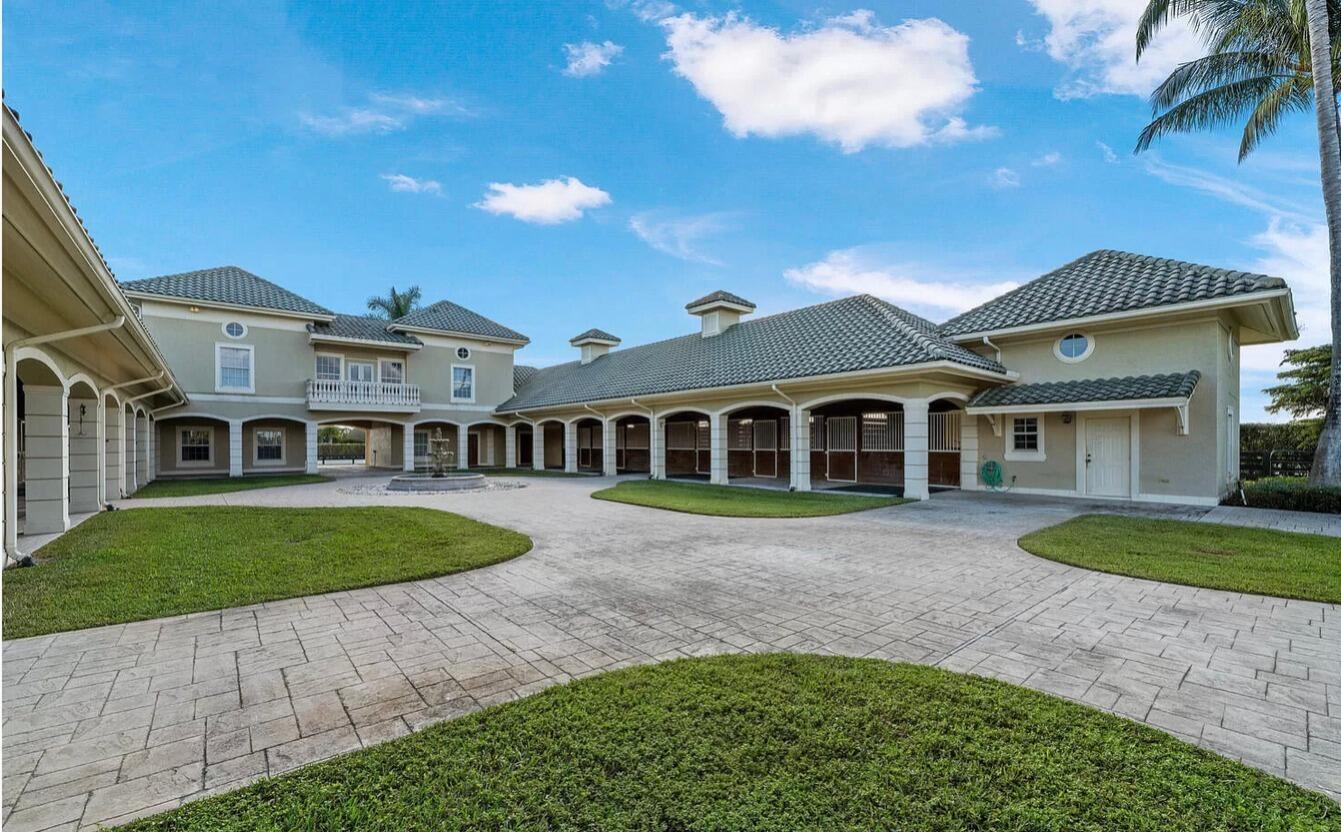 4591 S Road Wellington, FL 33414 - Photo 20 of 42 a front view of a house with a garden