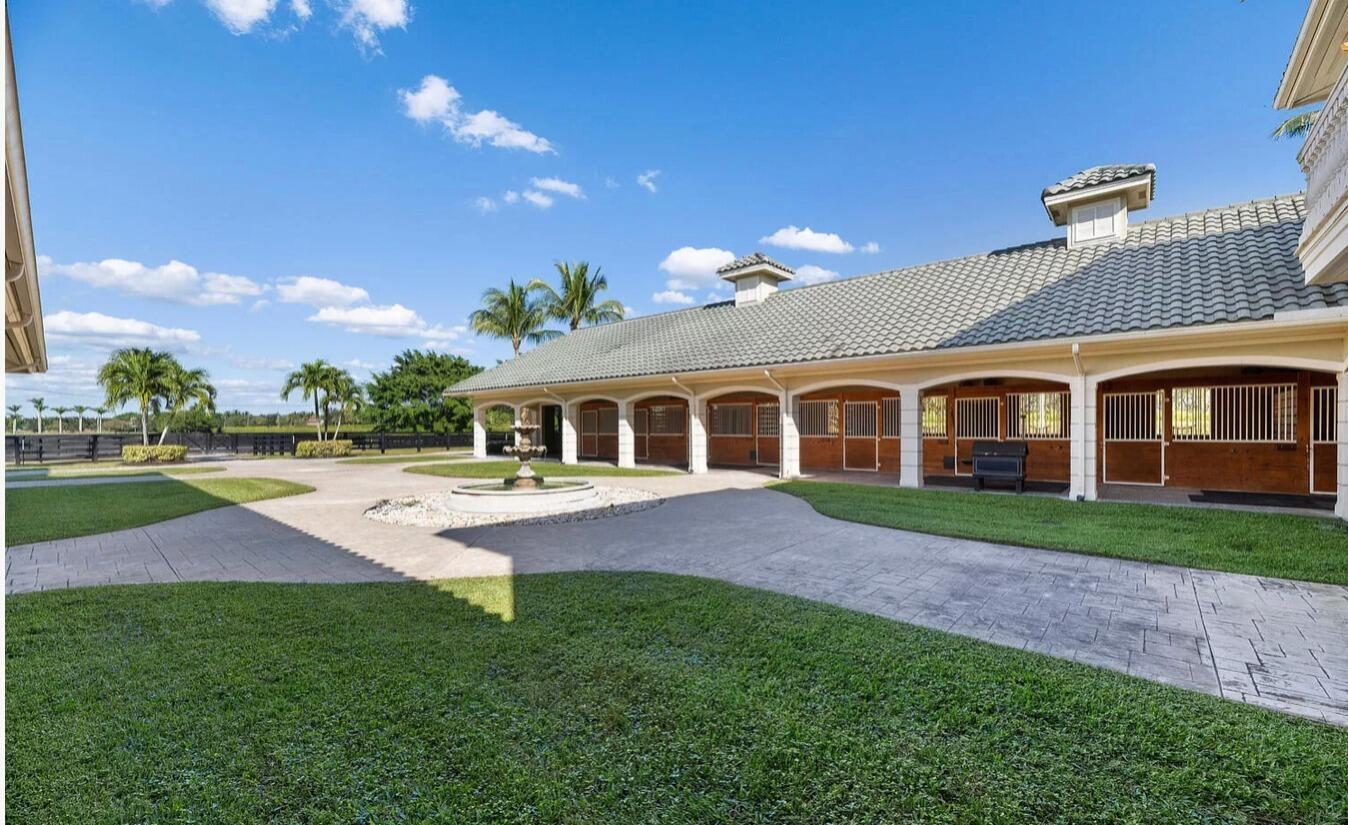 4591 S Road Wellington, FL 33414 - Photo 22 of 42 a front view of a house with a yard