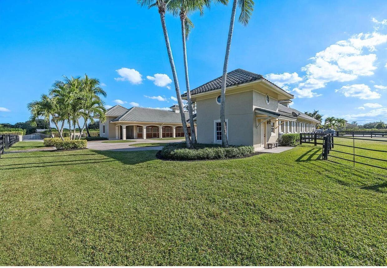 4591 S Road Wellington, FL 33414 - Photo 25 of 42 a front view of a house with garden
