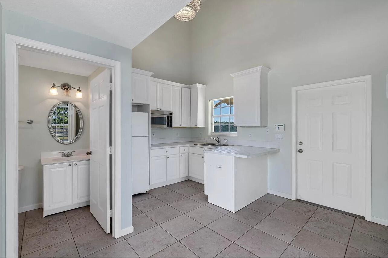 4591 S Road Wellington, FL 33414 - Photo 26 of 42 a kitchen with cabinets and white appliances