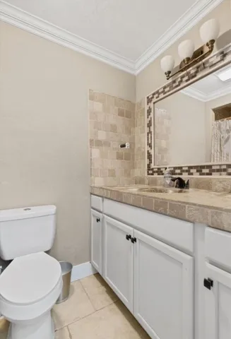 a bathroom with a granite countertop sink a toilet and a mirror