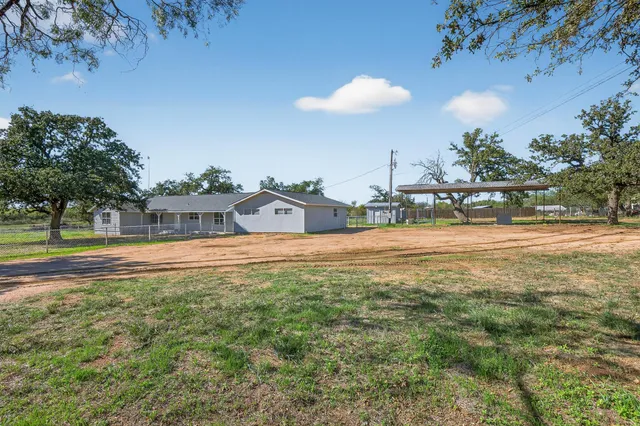 a view of a swimming pool with a lawn chairs and a fire pit