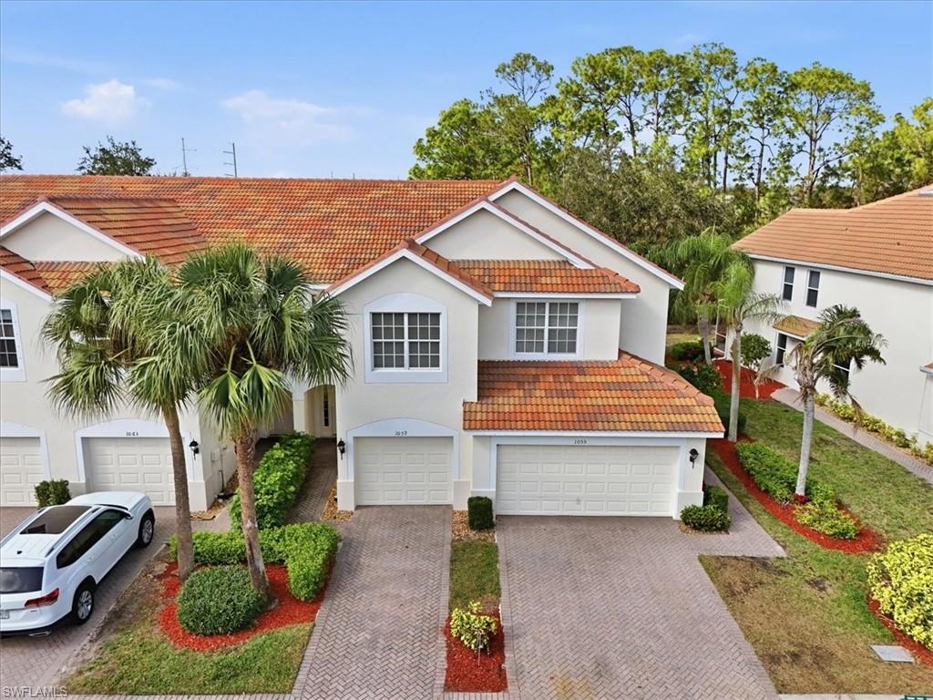 1059 Albany Court, Unit 218 Naples, FL 34105 - Photo 1 of 29 a front view of a house with garden