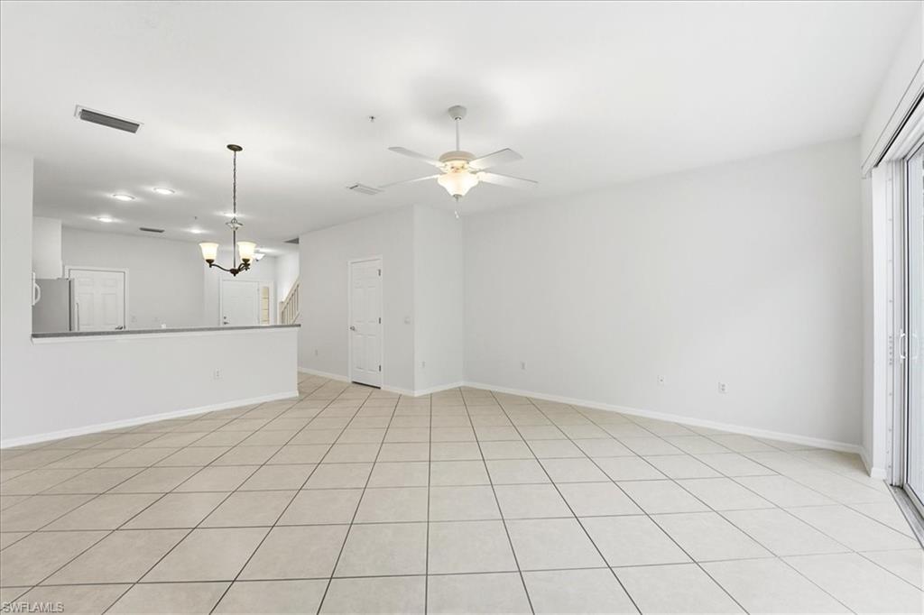 1059 Albany Court, Unit 218 Naples, FL 34105 - Photo 11 of 29 an empty room with kitchen view and a ceiling fan