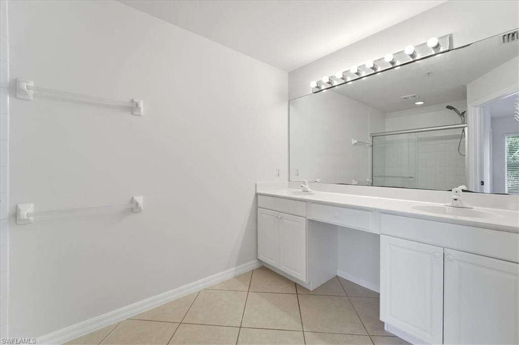 1059 Albany Court, Unit 218 Naples, FL 34105 - Photo 18 of 29 a bathroom with a sink and a mirror