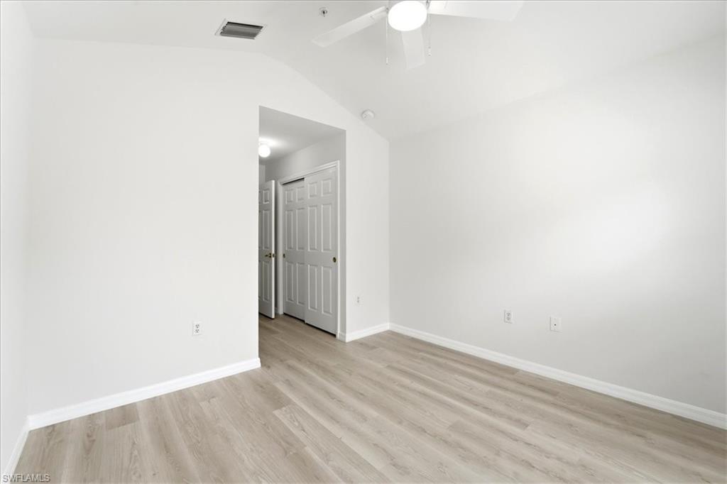 1059 Albany Court, Unit 218 Naples, FL 34105 - Photo 27 of 29 an empty room with wooden floor and mirror
