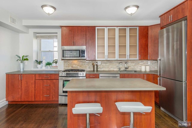 a kitchen with stainless steel appliances granite countertop a stove a sink dishwasher and a refrigerator