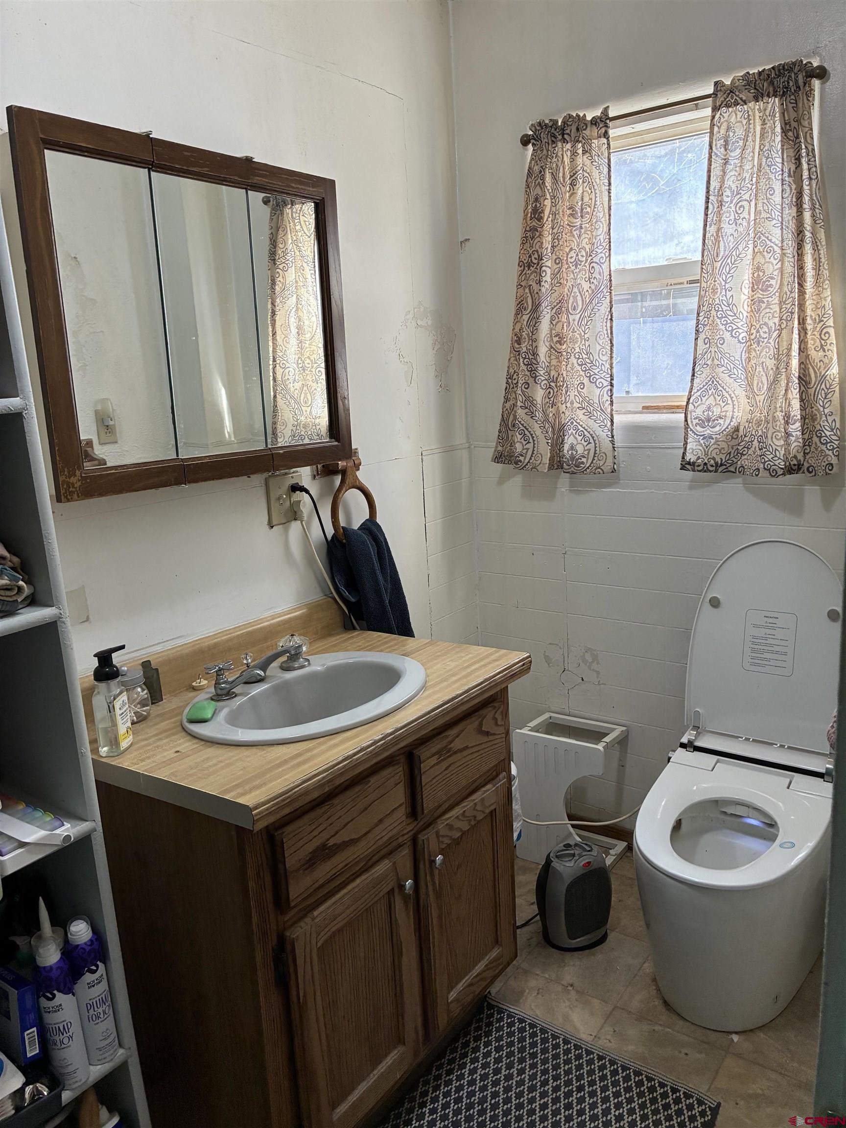 1002 State Avenue Alamosa, CO 81101 - Photo 10 of 19 a bathroom with a granite countertop toilet sink and mirror