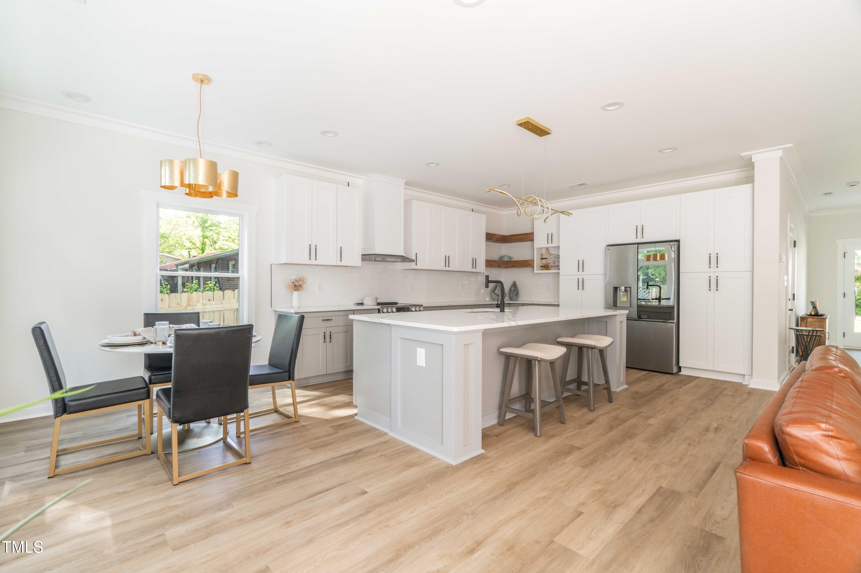 1124 Upchurch Street Raleigh, NC 27610 - Photo 11 of 45 a kitchen with a dining table chairs and white cabinets