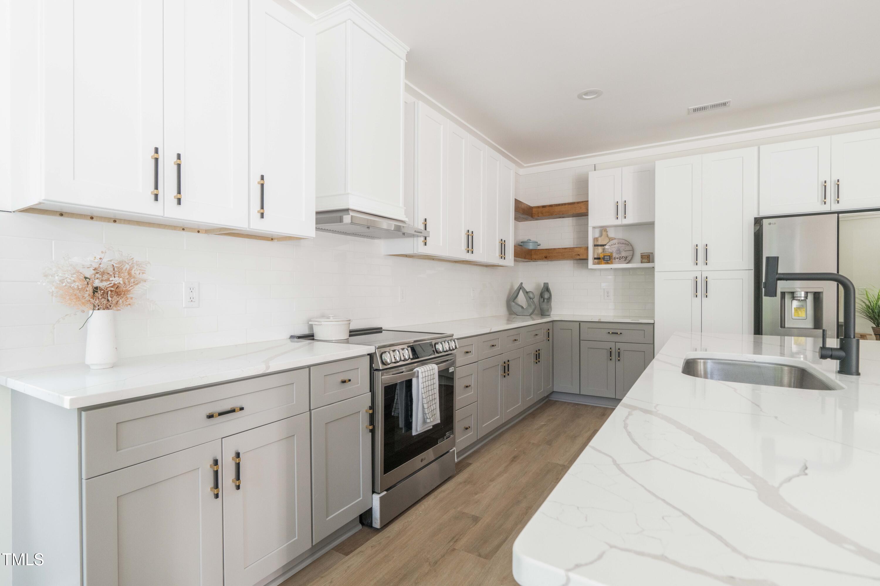 1124 Upchurch Street Raleigh, NC 27610 - Photo 14 of 45 a kitchen with white cabinets sink and white appliances