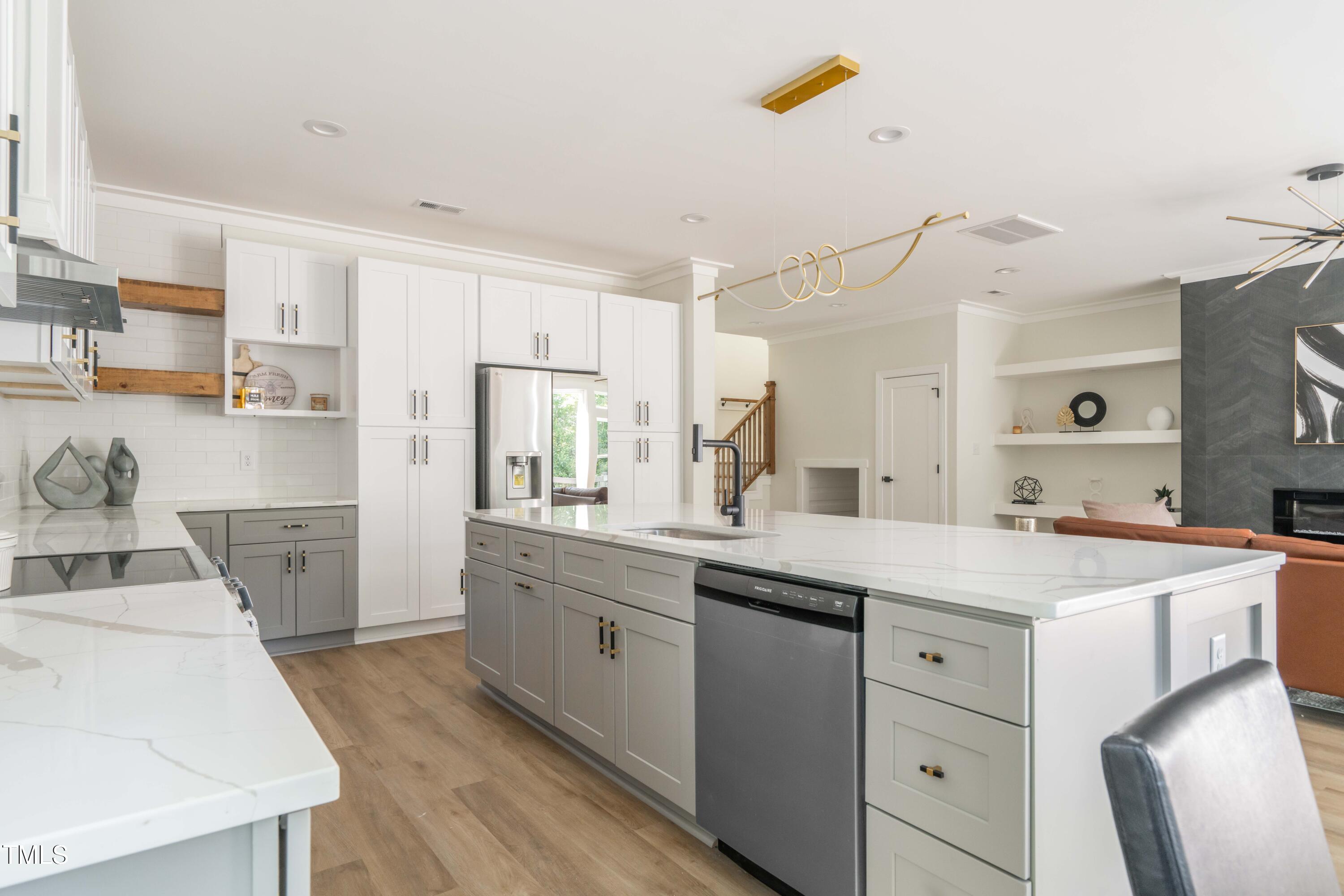 1124 Upchurch Street Raleigh, NC 27610 - Photo 16 of 45 a kitchen with a sink a stove a refrigerator and white cabinets