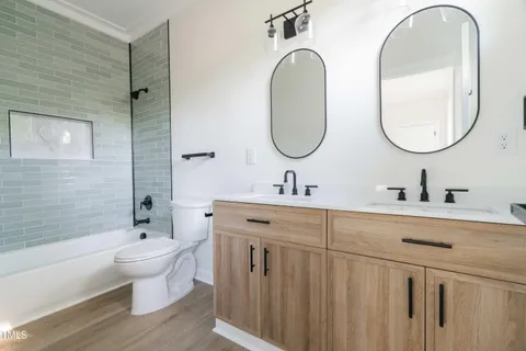 a bathroom with a double vanity sink mirror and toilet