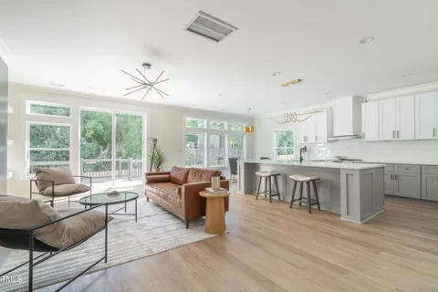 a living room with furniture a large window and a dining table