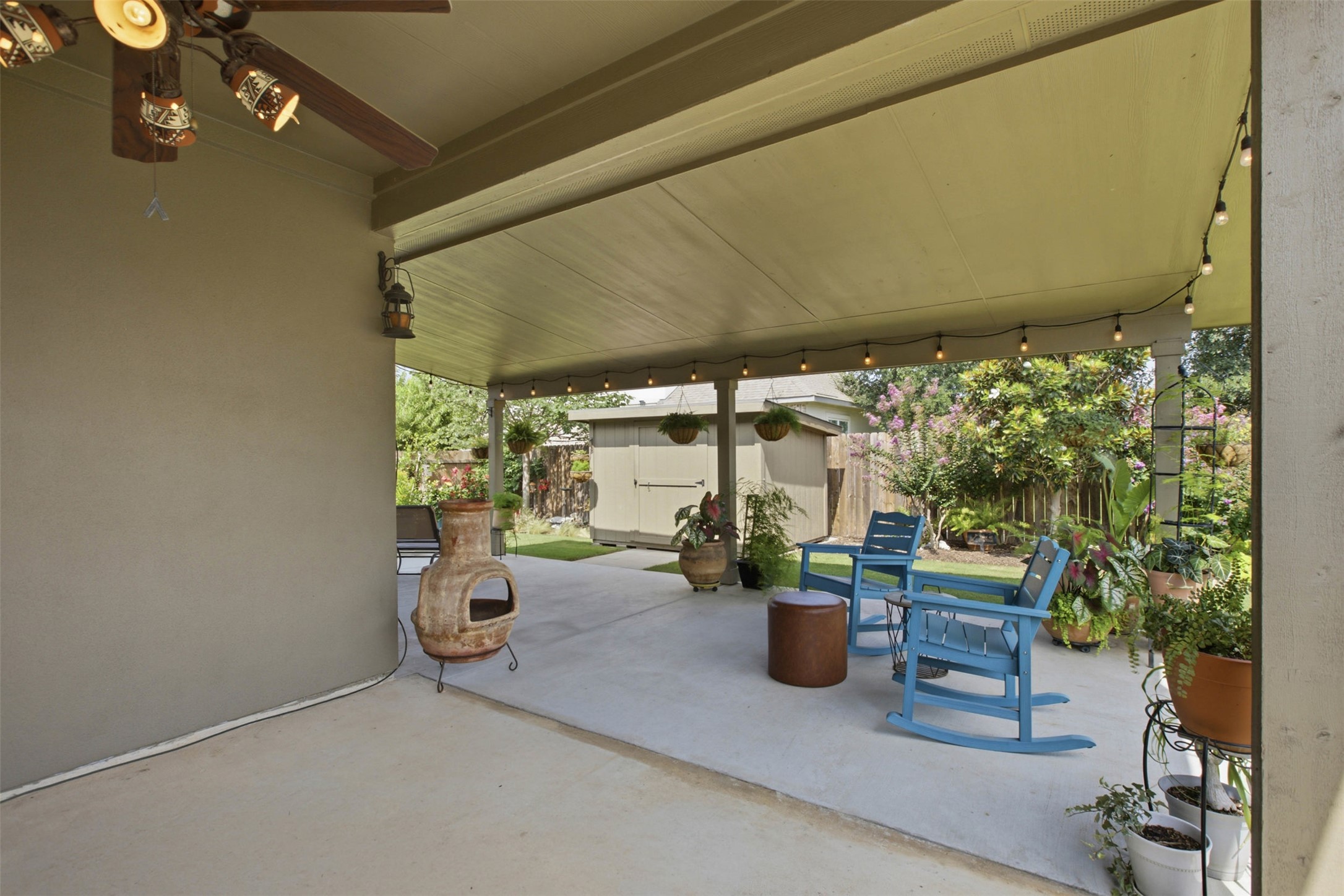 2413 Bridges Ranch Road Georgetown, TX 78628 - Photo 28 of 31 A spacious covered patio provides a delightful outdoor living area with a lush green backdrop.
