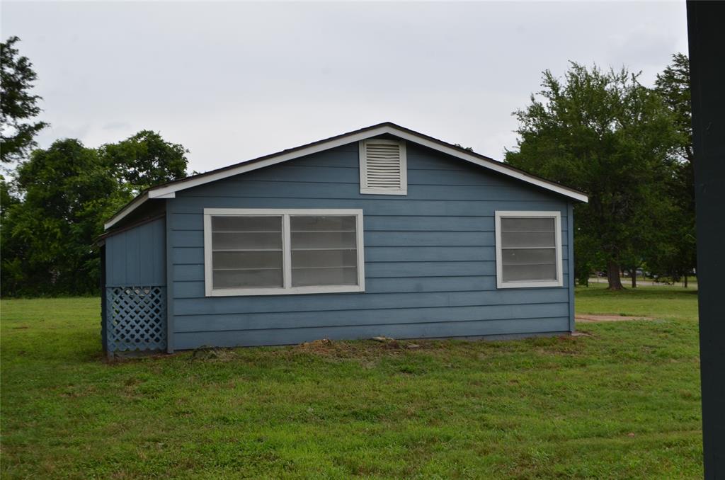 2020 Gage Road Cleburne, TX 76031 - Photo 4 of 12 Single-story structure featuring blue horizontal siding and a white-trimmed gable roof
