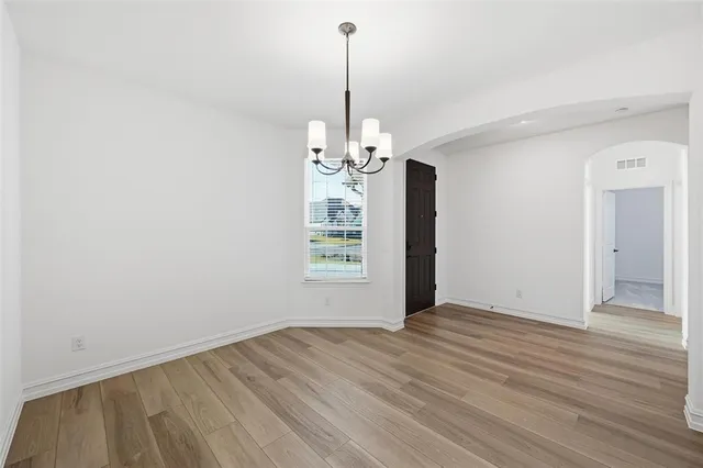 a view of a room with wooden floor chandelier and window