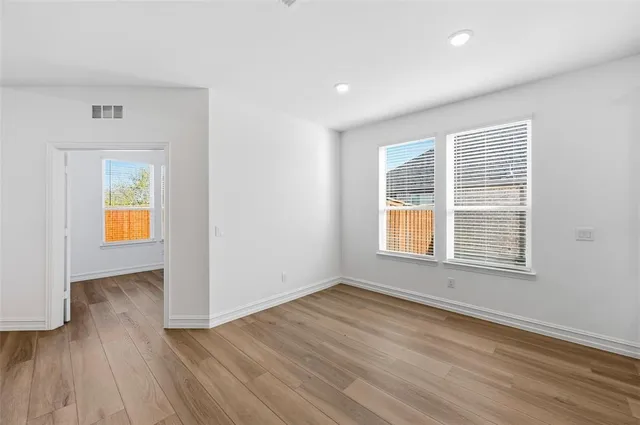 an empty room with wooden floor and a window