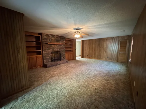 an empty room with a fireplace and cabinets