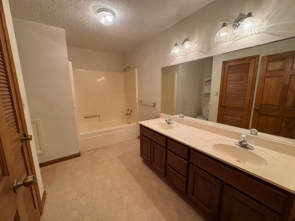 a bathroom with a double vanity sink a mirror and a shower