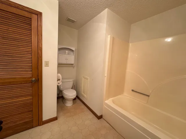 a bathroom with a granite countertop toilet a sink and bathtub