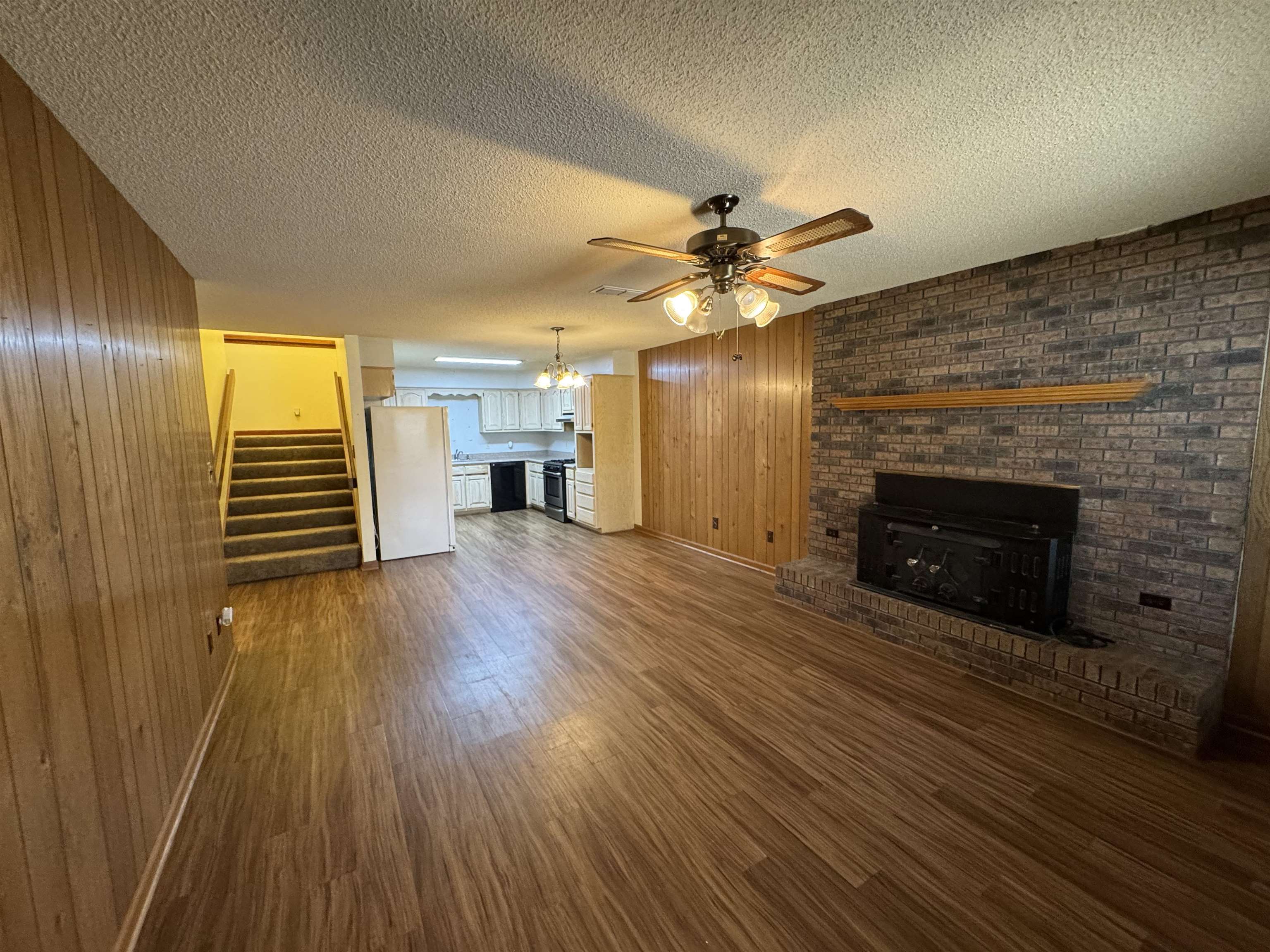 3360 Ebenezer Road Toone, TN 38381 - Photo 25 of 40 an empty room with wooden floor a fireplace and windows