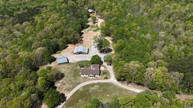an aerial view of a house with a yard and large trees