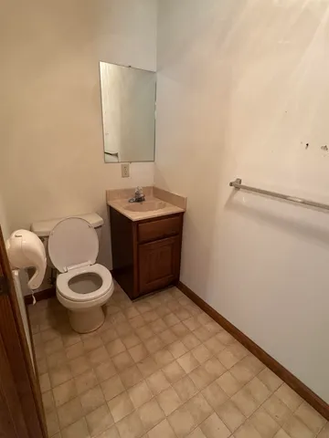 a bathroom with a toilet a sink and mirror