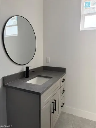 a bathroom with a granite countertop sink and a mirror