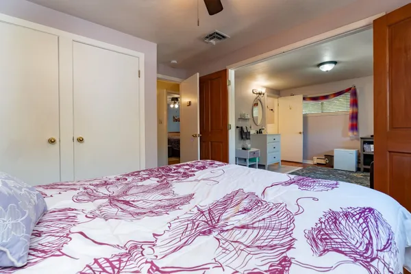 a bedroom with a large bed and a chandelier