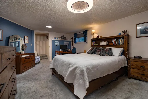 a bed sitting in a bedroom and kitchen