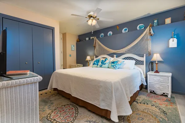 a bedroom with a bed and ceiling fan