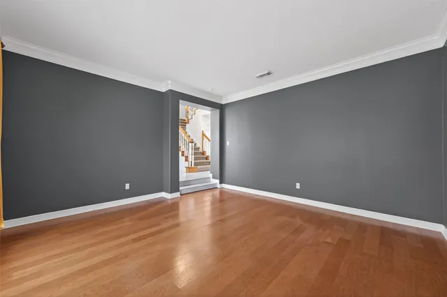an empty room with windows fireplace and wooden floor