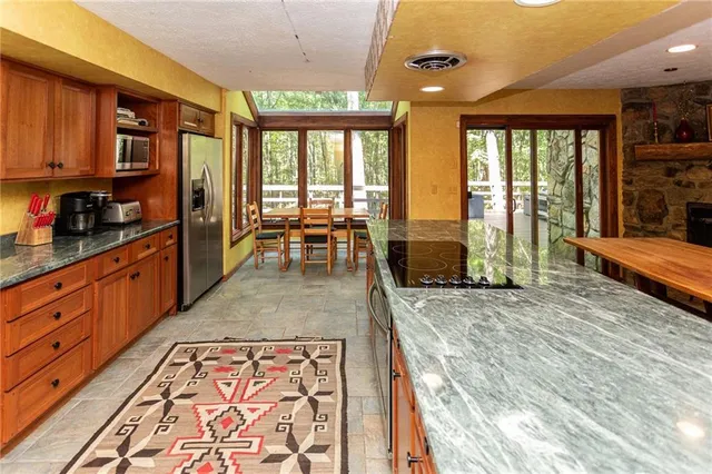 a large kitchen with kitchen island granite countertop a large window