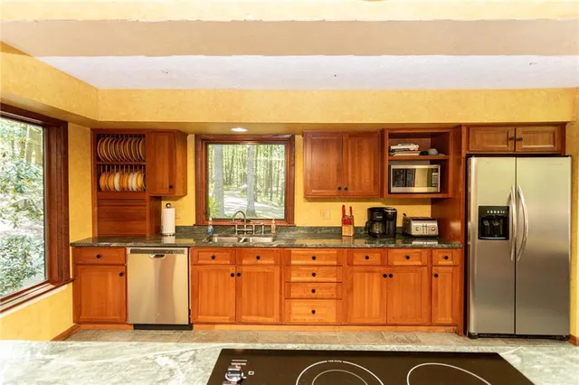 a kitchen with granite countertop a refrigerator and cabinets