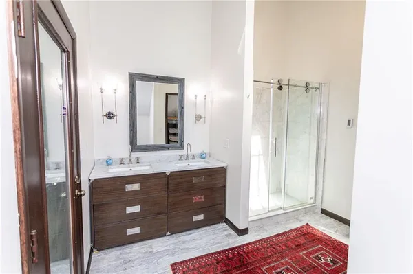 a view of a hallway with wooden floor and a bathroom