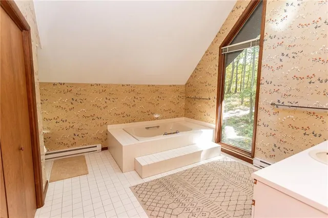 a bathroom with a bathtub sink and large window