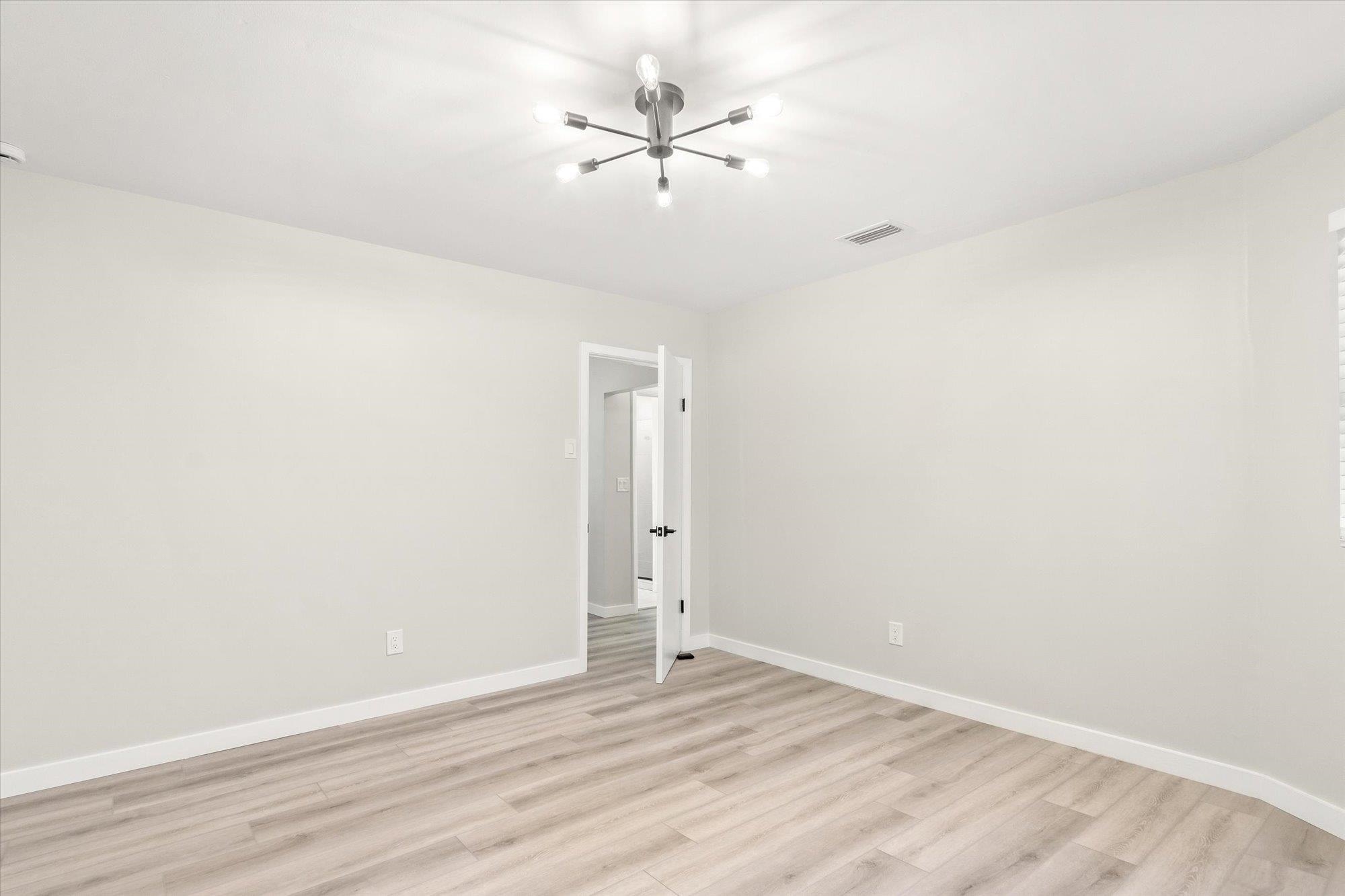 28 Sebastian Avenue, Unit A St. Augustine, FL 32084 - Photo 19 of 26 an empty room with a ceiling fan and wooden floor