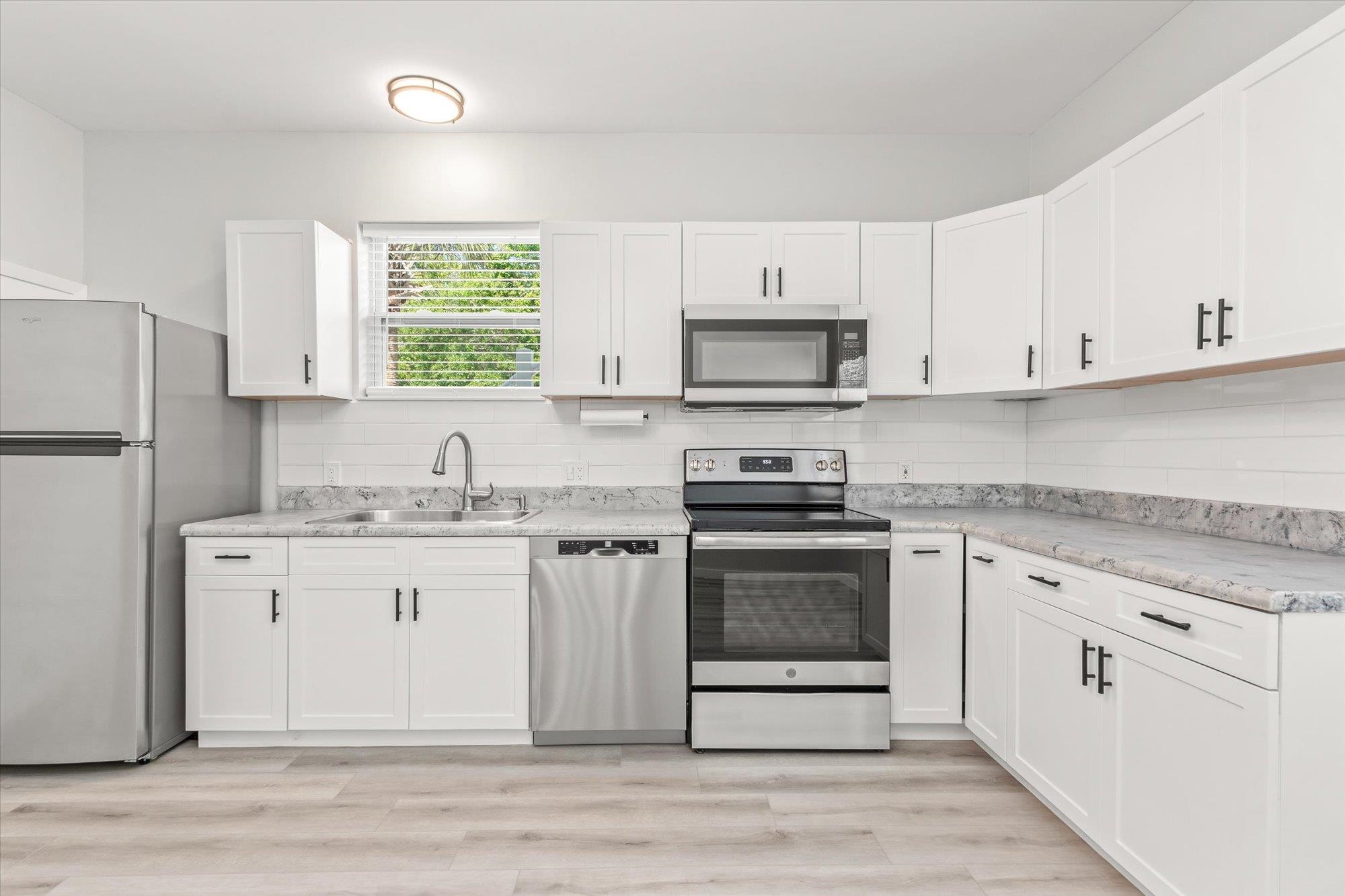 28 Sebastian Avenue, Unit A St. Augustine, FL 32084 - Photo 7 of 26 a kitchen with stainless steel appliances granite countertop a stove a sink and a refrigerator