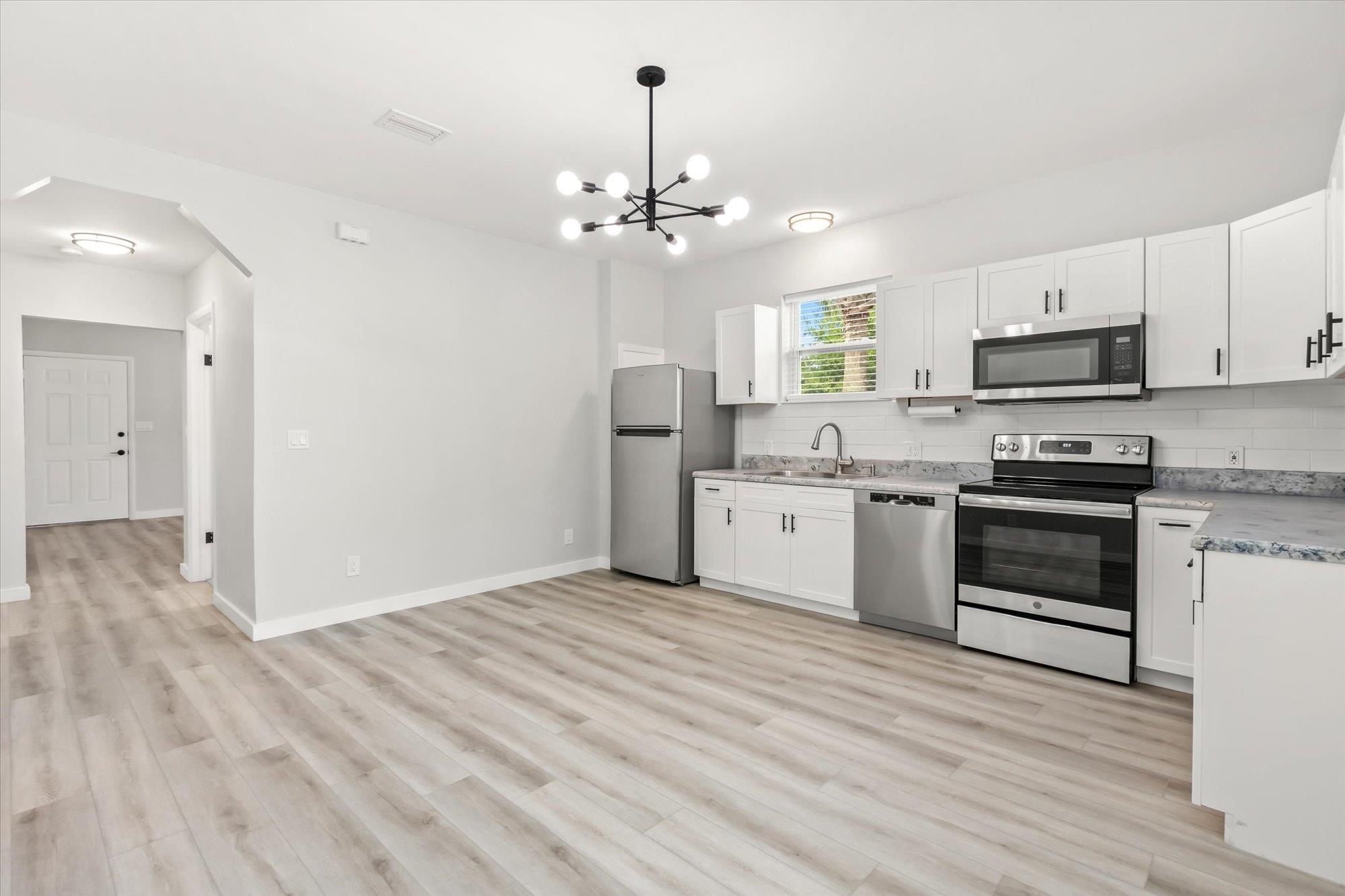 28 Sebastian Avenue, Unit A St. Augustine, FL 32084 - Photo 8 of 26 a kitchen with granite countertop a sink cabinets stainless steel appliances and a window