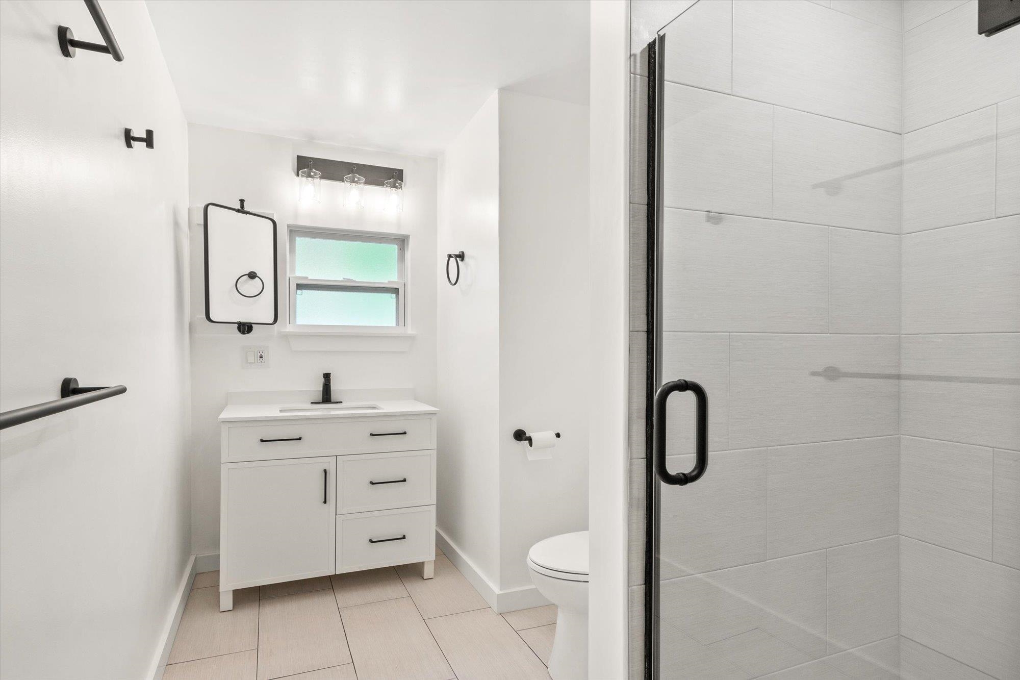 28 Sebastian Avenue, Unit A St. Augustine, FL 32084 - Photo 9 of 26 a bathroom with a toilet sink vanity and mirror