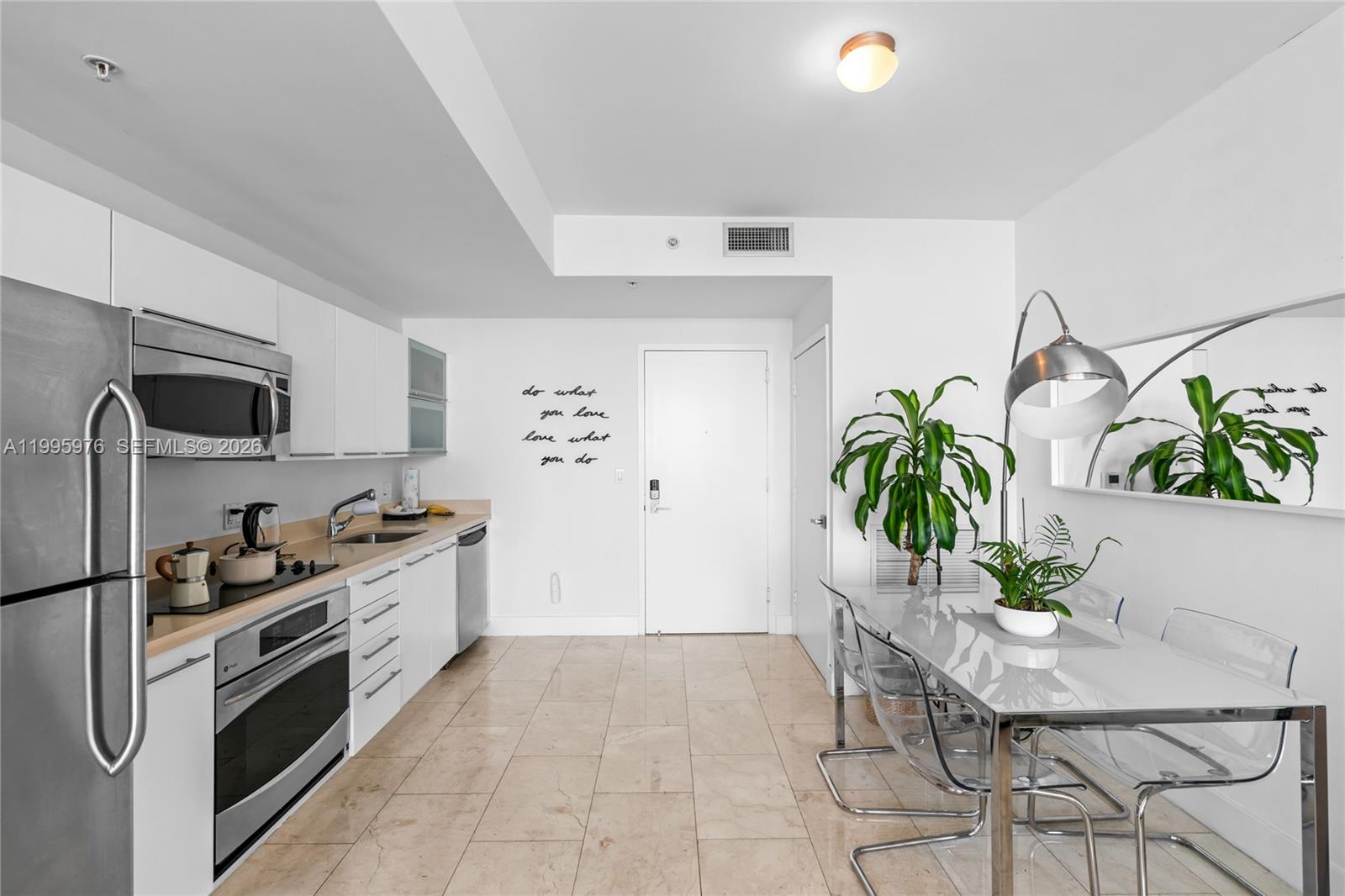 90 Southwest 3rd Street, Unit 1209 Miami, FL 33130 - Photo 10 of 33 a kitchen with stainless steel appliances a white stove top oven a counter space and cabinets