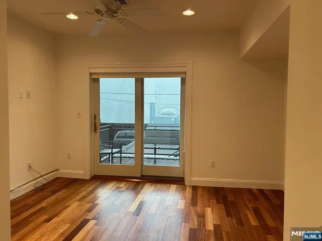a view of a room with wooden floor and white walls
