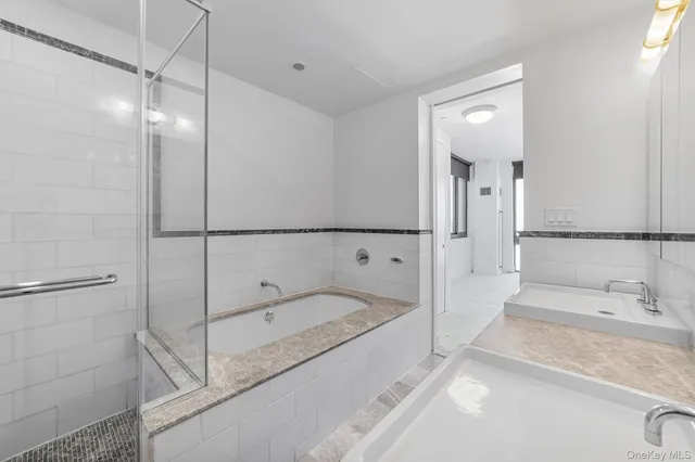 a bathroom with a tub sink and mirror