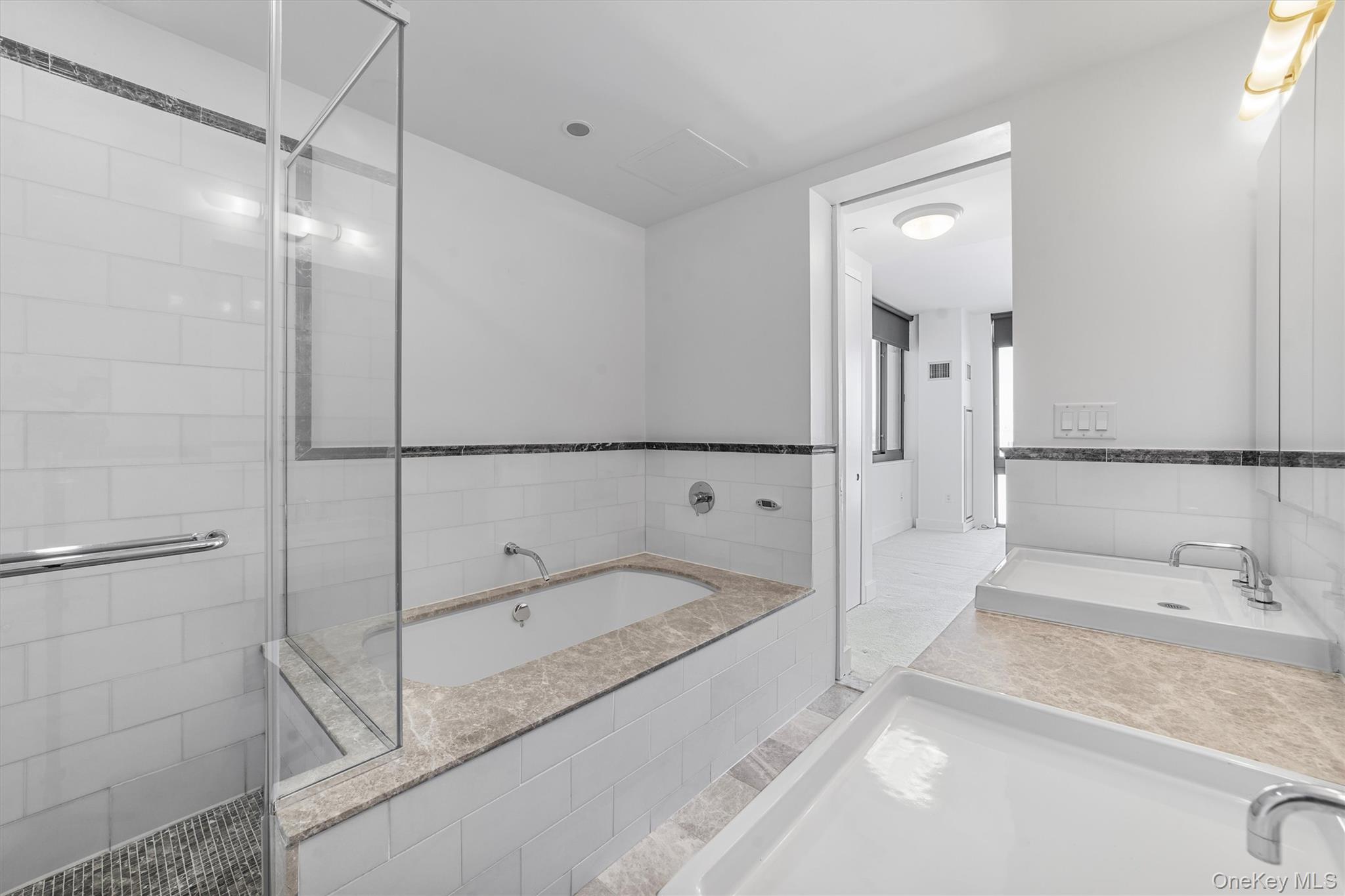 175 Huguenot Street, Unit 2108 New Rochelle, NY 10801 - Photo 14 of 18 a bathroom with a tub sink and mirror