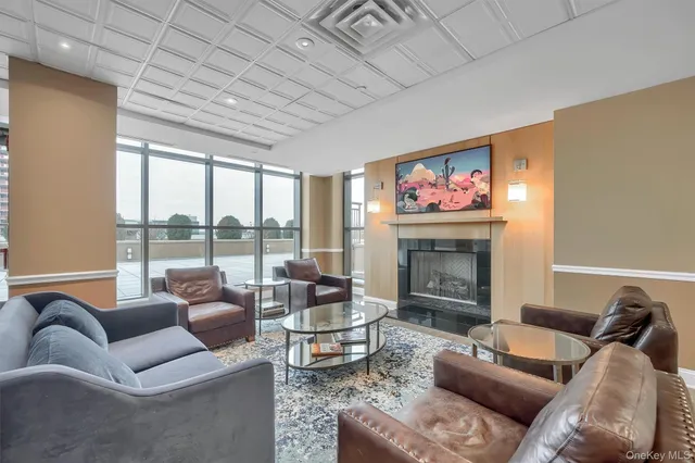 a living room with furniture a fireplace and a floor to ceiling window