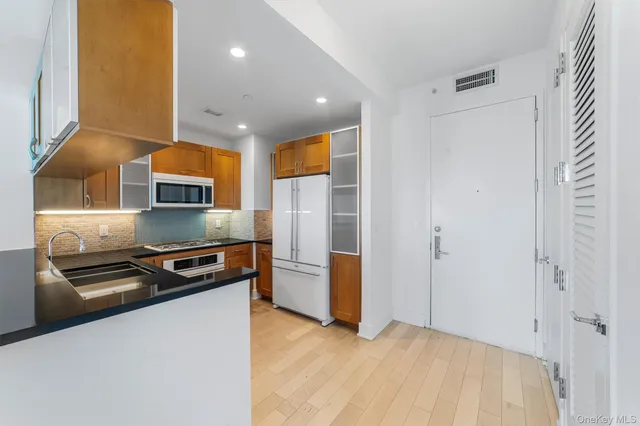 a kitchen with stainless steel appliances a refrigerator and a stove top oven